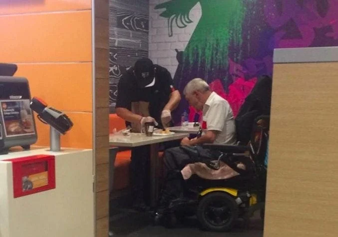 McDonald’s employee helps handicapped customer eat meal in viral photo – CBS News